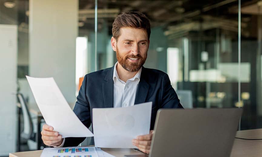 a male manager comparing and measuring his business performance